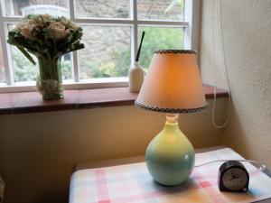 une lampe assise sur une table à côté d'une fenêtre dans l'établissement The Old Manor House B & B, à Brasted