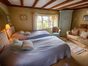 um quarto com 2 camas e um sofá em The Old Manor House B & B em Brasted