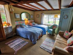 - une chambre avec deux lits et un canapé dans l'établissement The Old Manor House B & B, à Brasted