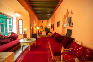 - un salon avec un canapé rouge et une table dans l'établissement Riad Dar Marhaba, à Marrakech