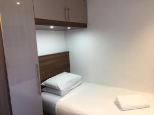 een kleine slaapkamer met een bed met 2 kussens bij The Marlborough Hotel in Liverpool
