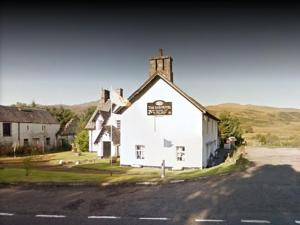 a white church with a sign on the front of it at Luib Hotel in Killin