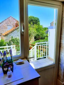 ein Küchenfenster mit Blick auf einen Balkon in der Unterkunft Apartments Neno in Korčula