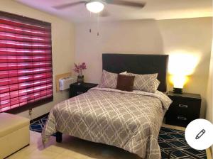 奇瓦瓦的住宿－Agradable* y Cómodo Departamento Familiar (WiFi)，一间卧室配有一张床和一个粉红色的窗户