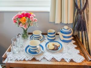 una mesa con platos azules y blancos y un jarrón de flores en Marshwood Farm B&B and Shepherds Hut, en Dinton