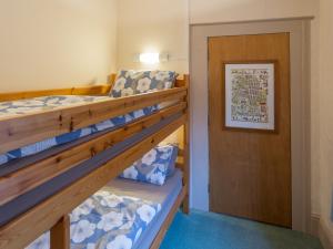 two bunk beds in a room with a door at The Cottage Marshwood Farm in Dinton