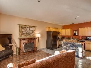 a living room with a fireplace and a kitchen at Leavenworth Village Inn in Leavenworth