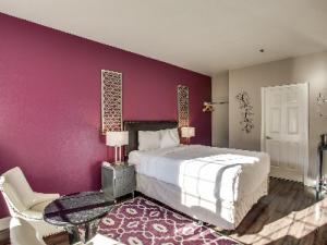 1 dormitorio con cama y pared púrpura en Leavenworth Village Inn, en Leavenworth