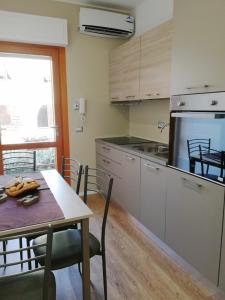 uma cozinha com uma mesa e uma mesa e cadeiras em HouseSandra Mare & Sole em Alghero