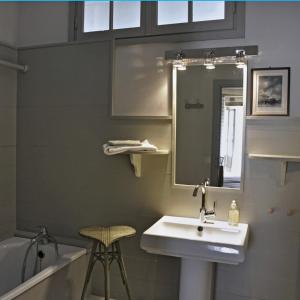 a bathroom with a sink and a mirror and a tub at La maison Jeanne d'Arc in Saint-Fargeau