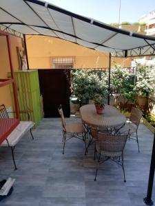 um pátio com uma mesa e cadeiras sob um dossel em HouseSandra Mare & Sole em Alghero