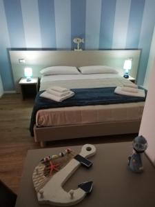 a bedroom with a bed with a knife on a table at HouseSandra Mare & Sole in Alghero