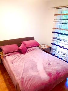 - un lit avec des draps et des oreillers roses dans l'établissement Dream apartment Herceg Novi, à Herceg-Novi