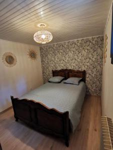 a bedroom with a bed and a chandelier at Gîte 2 chambres avec piscine in Sernhac