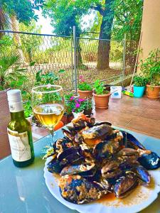 une assiette d'huîtres et un verre de vin sur une table dans l'établissement Dream apartment Herceg Novi, à Herceg-Novi