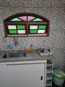 een keuken met een wastafel en een raam erboven bij Casa de praia completa em Cabo Frio - Melhor Custo x Benefício in Cabo Frio