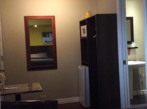 a room with a mirror and a black cabinet at Miami Motel inc in Trois-Rivières