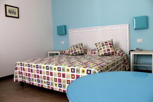 a bedroom with a bed with a colorful bedspread at Hotel O'scià in Lampedusa