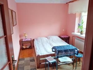 a small bedroom with a bed and a table at Odpoczywalnia in Opatów