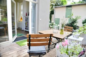 a patio with a wooden table and chairs on a porch at JETHON Studio-Appartement im Grünen in Bernburg