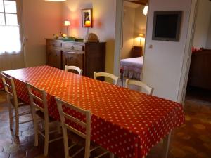 una mesa de comedor con un paño de lunares rojo y blanco en Gite du moulin de Blanville, en Saint-Luperce