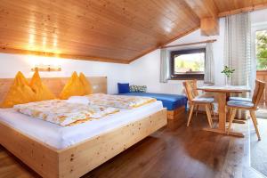 a bedroom with a bed and a table and chairs at Haus Obermühle in Maria Alm am Steinernen Meer