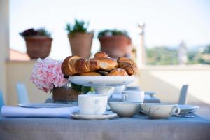 a plate of pastries on a table with cups and flowers at Dimora de Matera Luxury Suites in Cosenza