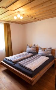 a large bed in a room with a wooden ceiling at GamserlAlm Fam. Feichtenhofer in Turnau