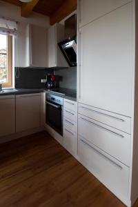 a kitchen with white cabinets and a stove at GamserlAlm Fam. Feichtenhofer in Turnau