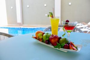 a plate of fruit on a table with a drink at Hotel Barlovento in Cartagena de Indias