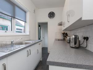 a kitchen with white cabinets and a sink and a window at Townhouse @ Newlands Street Stoke in Etruria