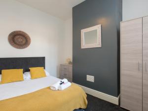 a bedroom with a bed with a yellow blanket at Townhouse @ Newlands Street Stoke in Etruria
