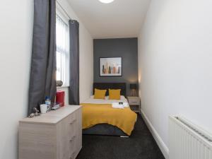 a bedroom with a bed with yellow sheets and yellow pillows at Townhouse @ Newlands Street Stoke in Etruria +15 photos