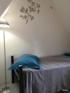 ストラスブールにあるLe Nid de la Cathedraleのベッドルーム1室(青い枕とランプ付きのベッド1台付)