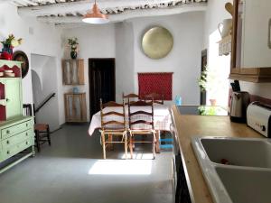 a kitchen with a table and chairs in a room at Casa Carmela, rural house with spectacular views, in an exquisite area in Atalbéitar