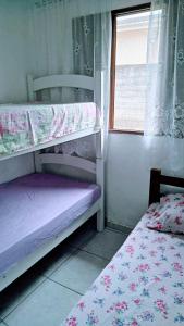 um quarto com 2 beliches e uma janela em Cantinho do sossego em Caraguatatuba