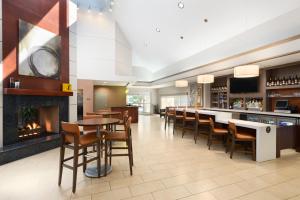 a lobby with a bar and chairs and a fireplace at CLT Sky Suites in Charlotte