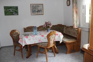 stół jadalny z krzesłami i stół z kwiatami w obiekcie Ferienhaus am Klosterhof w mieście Immendingen