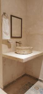 a bathroom with a stone sink and a mirror at Hotel Casa Bamboo in Valladolid