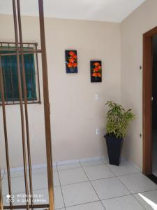 a room with three pictures on the wall and a plant at Aconchego Ferreira,só para famílias in Conde