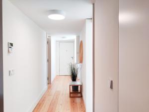 a hallway of an apartment with white walls and wooden floors at FLH Downtown Modern Apartment in Lisbon