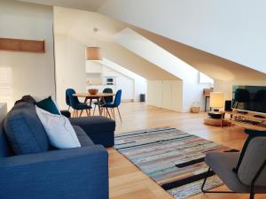 ein Wohnzimmer mit einem blauen Sofa und einem Tisch in der Unterkunft FLH Downtown Modern Apartment in Lissabon