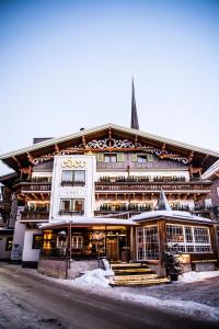 ein großes weißes Gebäude mit einem Gebäude in der Unterkunft Lifestyle Hotel eder in Maria Alm am Steinernen Meer