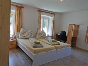 a bedroom with a large white bed and a desk at Amtmannhaus Ferienunterkunft Irdning Ennsradweg Budgetzimmer in Irdning