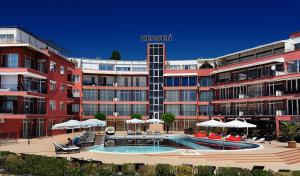 un hotel con piscina frente a un edificio en Heaven Lux Apartments, en Sunny Beach