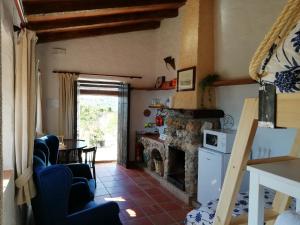 a living room with a fireplace and a table at Cortijo Las Monjas in Periana