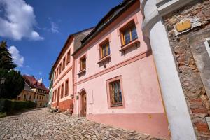 un bâtiment rose sur le côté d'une rue dans l'établissement Diviš73, à Loket