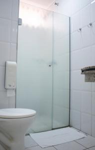 y baño con ducha de cristal y aseo. en Vancouver Hotel- 500 Metros Rodovia Anhanguera, en Ribeirão Preto
