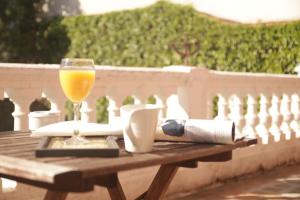 una mesa de madera con un vaso de zumo de naranja. en Hotel Villa Maria en Fuentes de Béjar