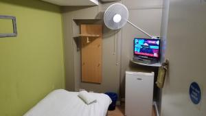 a hospital room with a bed and a television at City View Hotel Roman Road in London